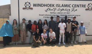 A group of students pose in front of a sign that reads Windhoek Islamic Centre